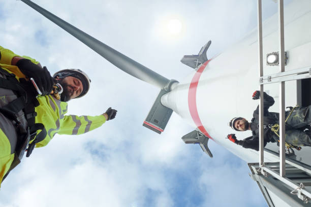 manual high workers working on biggest wind-turbine - service rig imagens e fotografias de stock