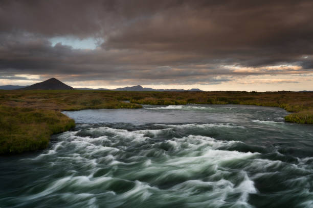 Blue river captured with long exposure among valley in South Iceland stock photo