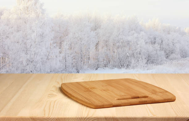 istock wooden table with cutting Board on blurred winter background. 1059331128
