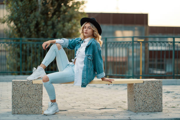 istock A modern, stylish girl posing while sitting on a minimal city bench 1059334824