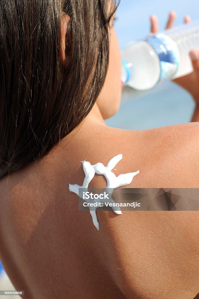 Chica joven en la playa con sol en forma de crema de sol - Foto de stock de Adolescente libre de derechos