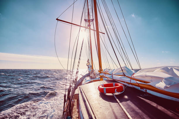 segeln gegen die sonne. - sailboat sunset nautical vessel sun stock-fotos und bilder