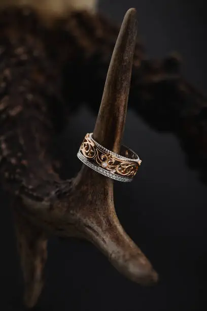 Photo of Pink gold and white gold ring with floral pattern on black background