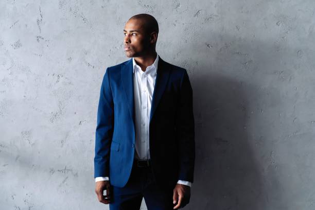 istock Cool african businessman standing on grey background. 1059341710