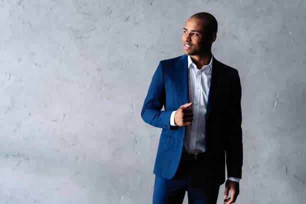istock Cool african businessman standing on grey background. 1059341714