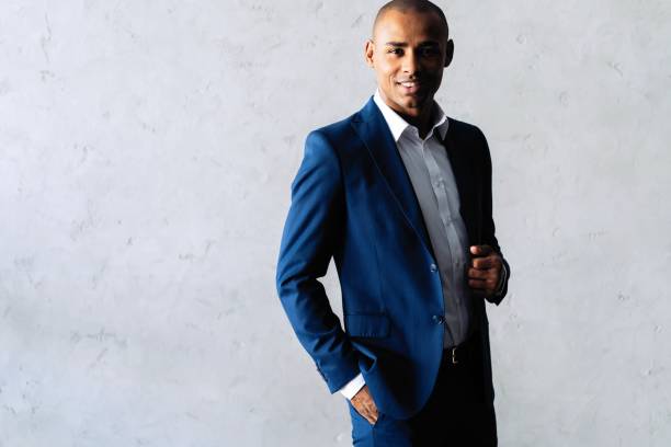 istock Cool african businessman standing on grey background. 1059341716