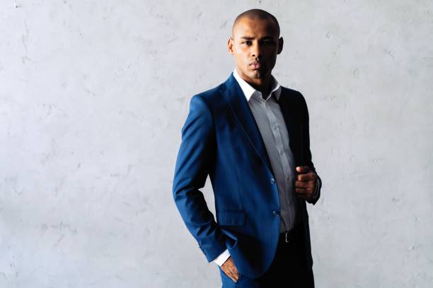 istock Cool african businessman standing on grey background. 1059341724