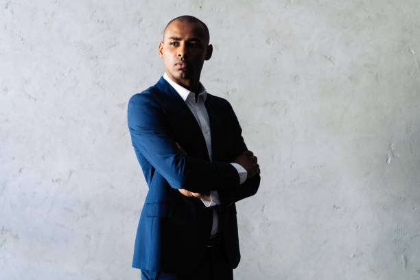 istock Cool african businessman standing on grey background. 1059341730