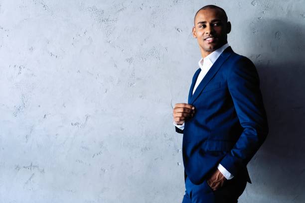 istock Cool african businessman standing on grey background. 1059341754