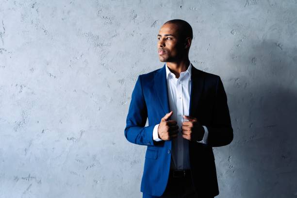 istock Cool african businessman standing on grey background. 1059341776