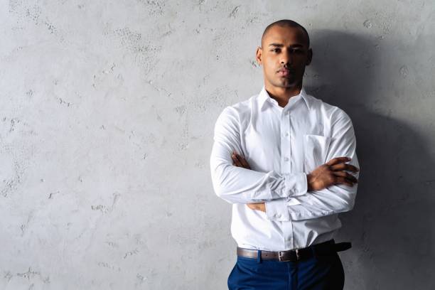 istock Cool african businessman standing on grey background. 1059341802