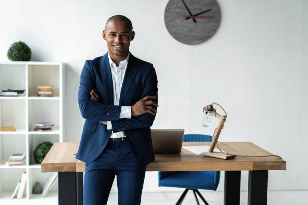istock Handsome cheerful african american executive business man at the workspace office. 1059342864