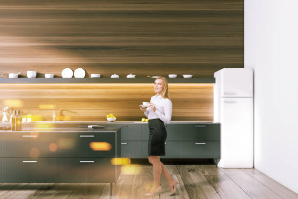 istock Woman in black and dark wooden kitchen interior 1059344670