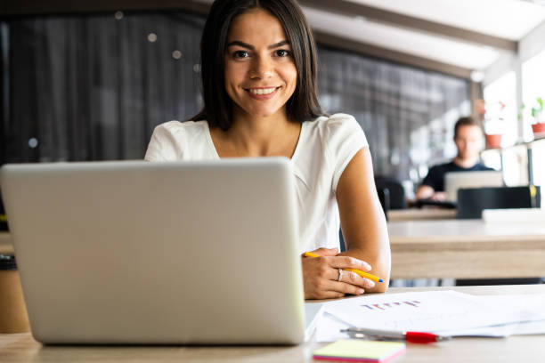 istock New solution every day. Confident young woman in smart casual wear working on laptop while sitting at her working place in office. 1059344824