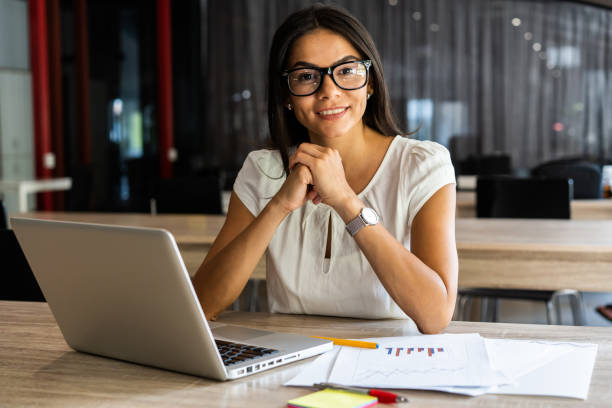 istock New solution every day. Confident young woman in smart casual wear working on laptop while sitting at her working place in office. 1059344854