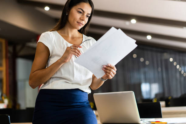 istock Looking for the right document. Beautiful young woman examining documents in office 1059347506