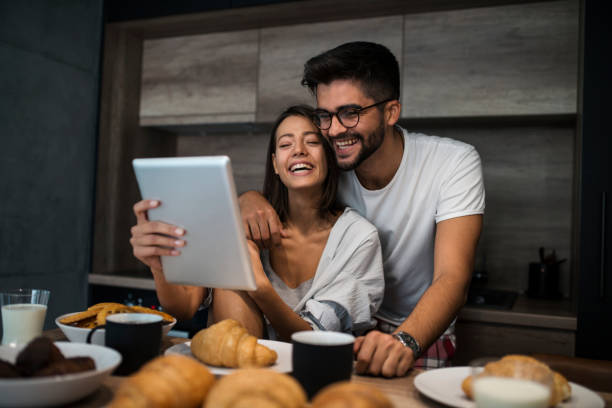 istock Young couple at home using digital tablet  - Morning breakfast time 1059351482