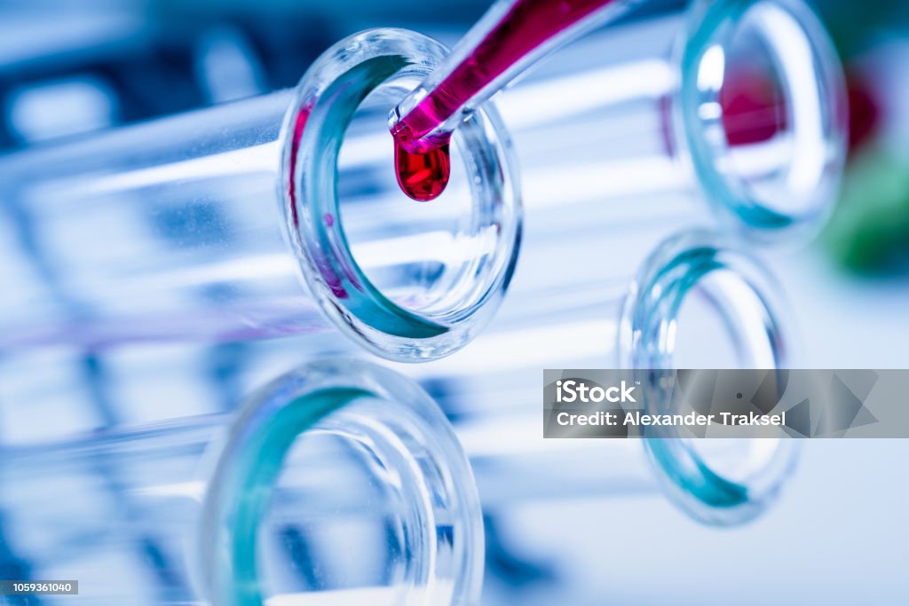 Pipette adding fluid to one of several test tubes .medical glassware. Pipette adding fluid to one of several test tubes .medical glassware Development Stock Photo
