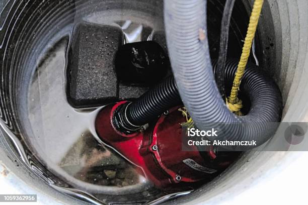 A Sump Pump With Some Water Around It Stock Photo - Download Image Now - Water Pump, Basement, Flood