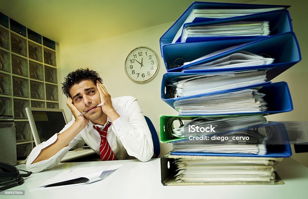 monkey business exhausted businessman surrounded by files Adult Stock Photo