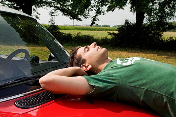 cool guy resting on the bonnet of his car
