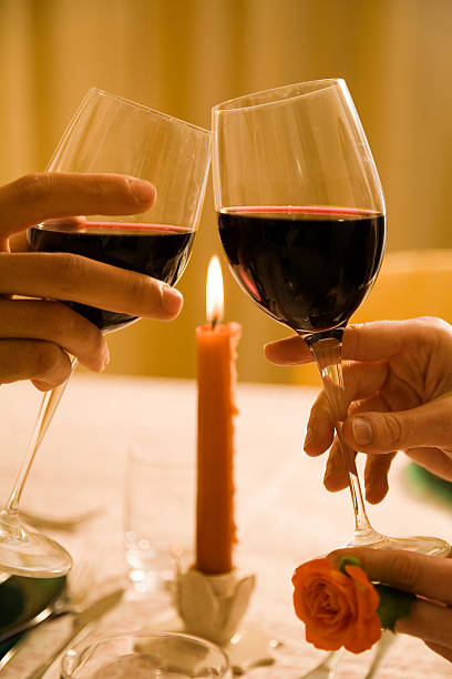 istock Hands toasting with red wine glasses on a candle lit dinner 105937325