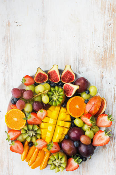 istock Rainbow fruits berries on white wood 1059376136
