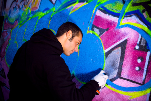 urban lifestyle: young man painting on a wall