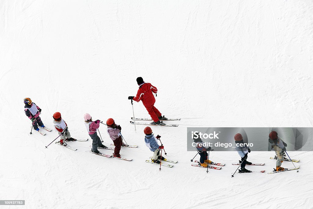 Aerial shot of a group of young skiers and instructor winter scene: kids learning to ski and their instructor. There are no recognizable persons Skiing Stock Photo