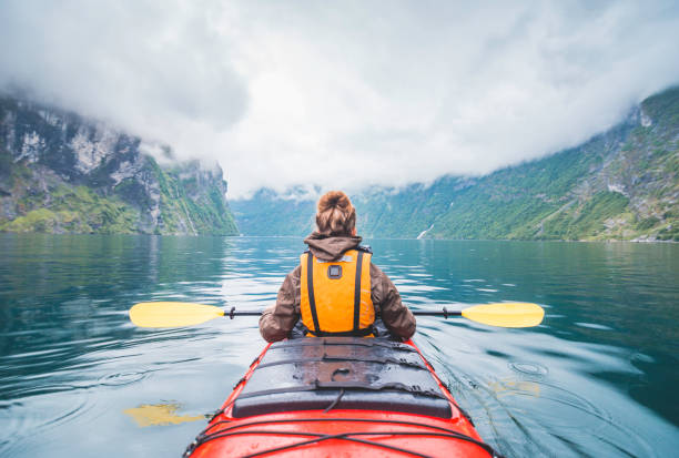 donna in kayak nel fiordo in norvegia. - water sport lake canoe canoeing foto e immagini stock