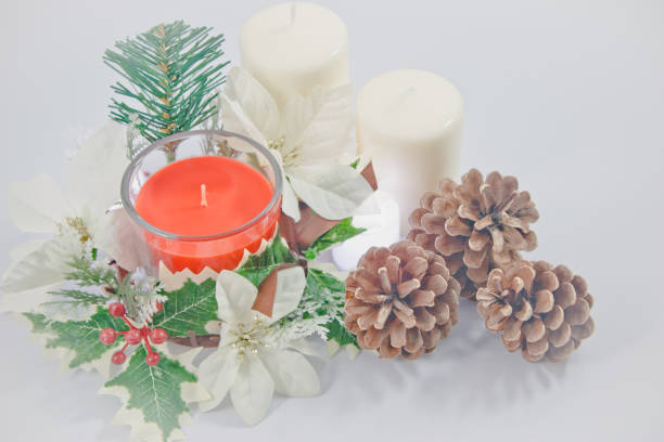 istock Christmas flowers with red candlestick and pine cone branches with 2 white candle. Christmas Ornament decor on table 1059381654