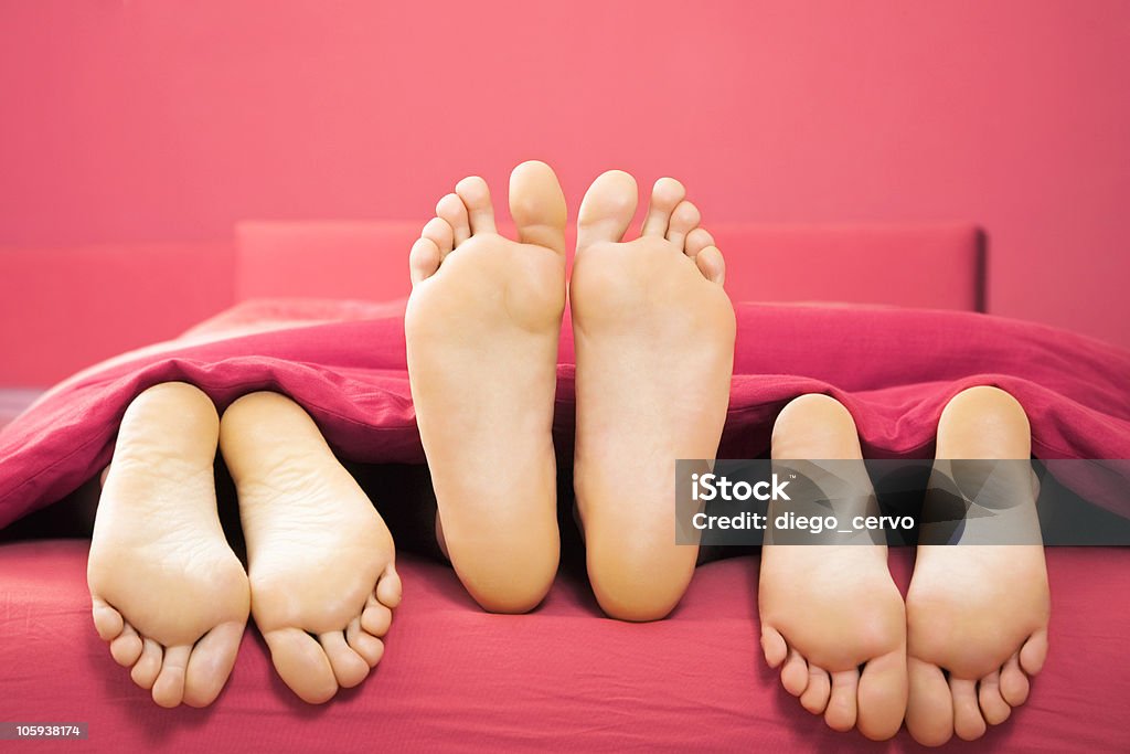 domestic life domestic life: threesome sharing the same bed Three People Stock Photo