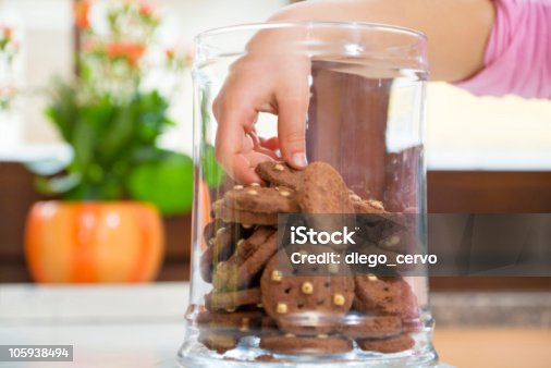 istock Children's hand in the cookie jar grabbing a cookie 105938494