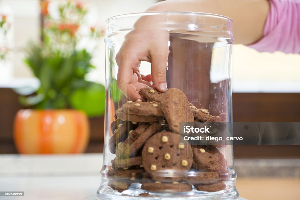 Children's hand in the cookie jar grabbing a cookie little girl stealing some cookies from the jar Cookie Stock Photo