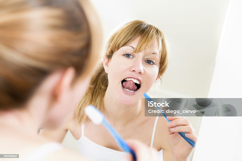 Odbicie kobieta szczotkowanie zębów rano - Zbiór zdjęć royalty-free (Lustro)