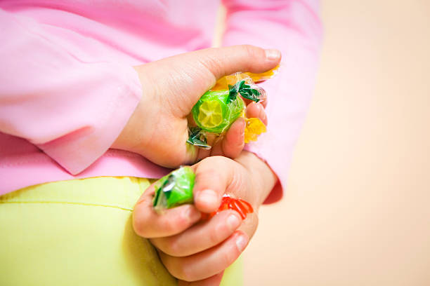 children44 little girl hiding some candies in her hands hands behind back stock pictures, royalty-free photos & images