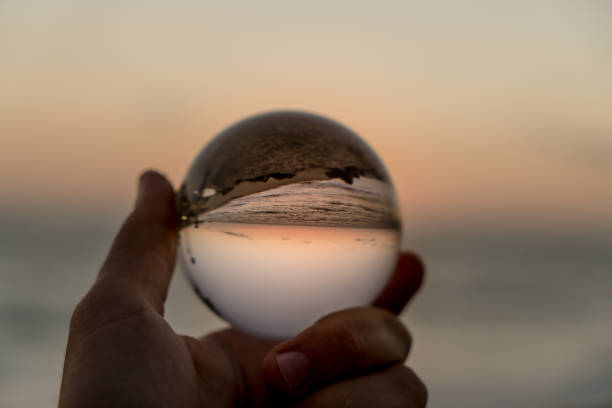 istock Hand holding a crystal ball on the beach 1059388184