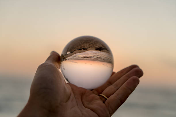 istock Hand holding a crystal ball on the beach 1059388190