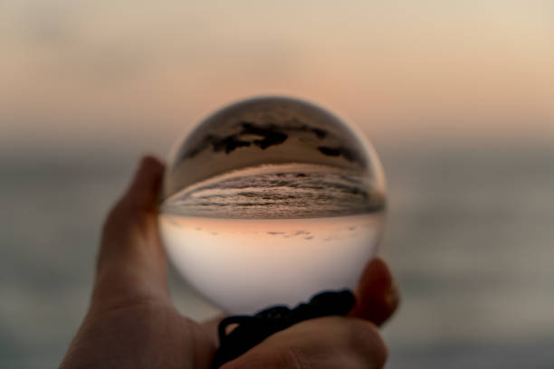 istock Hand holding a crystal ball on the beach 1059388196