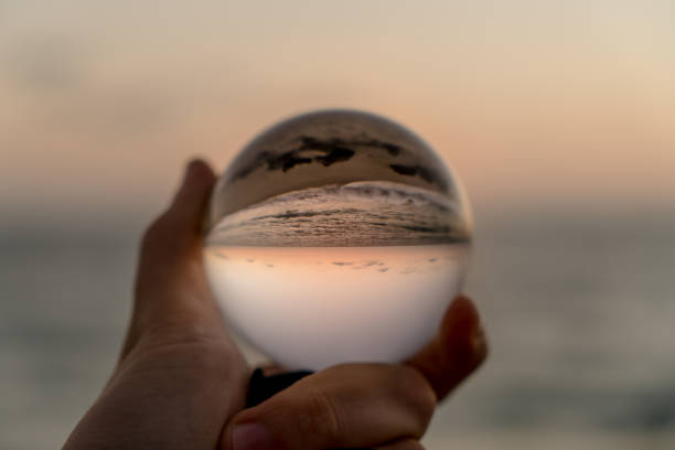 istock Hand holding a crystal ball on the beach 1059388220