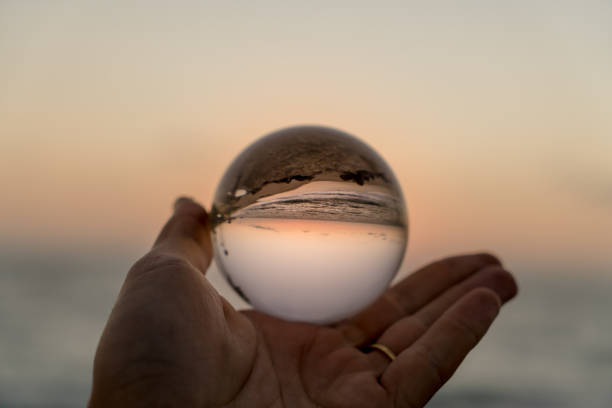 istock Hand holding a crystal ball on the beach 1059388222