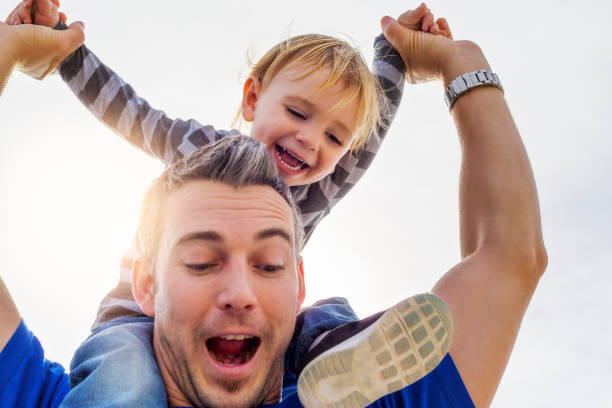 istock Young Dad carrying laughing toddler son on shoulders 1059391098