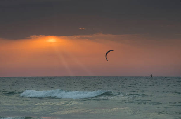 istock Rays of sunshine during a sunset upon a  wind surfer 1059392970