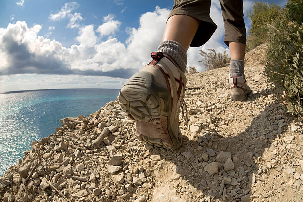 young woman hiking on a cliff near the sea