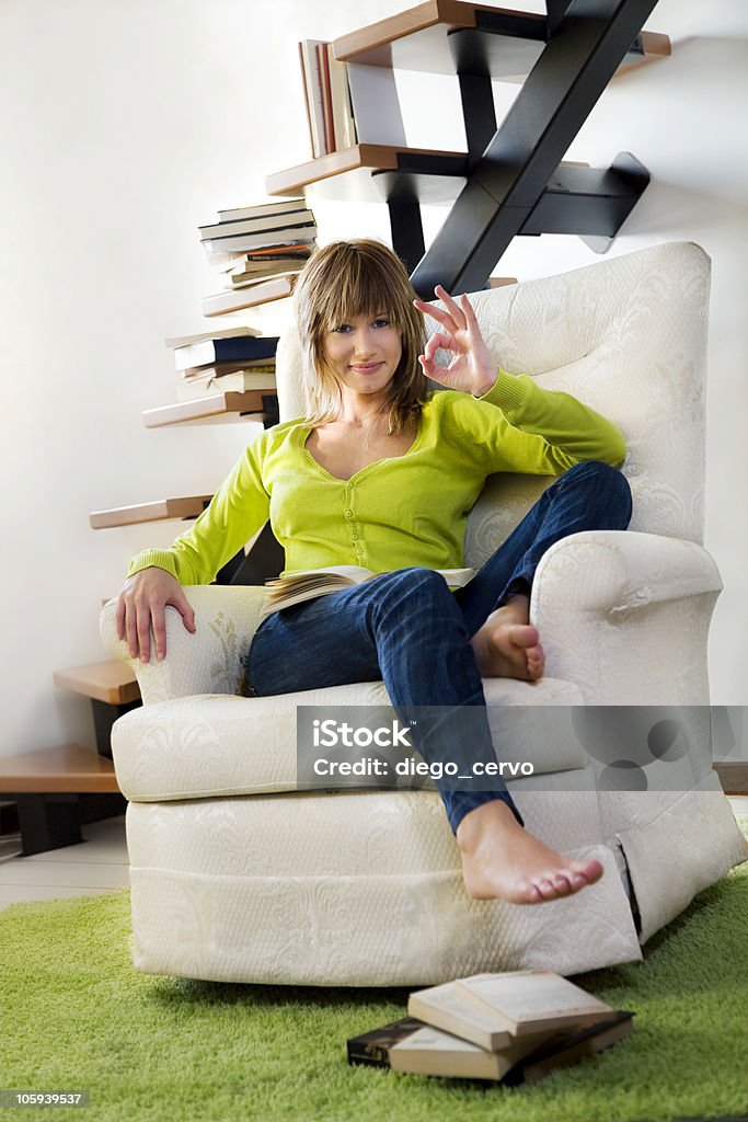 armchair Portrait of young woman relaxing in chair at home 20-29 Years Stock Photo