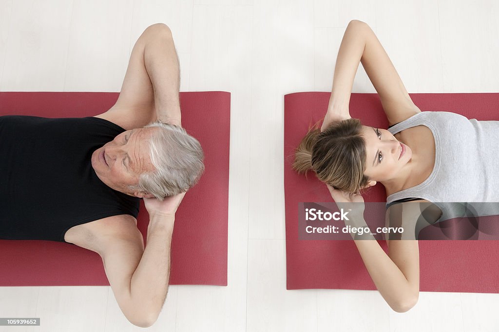 fitness and yoga young woman and senior adult exercising in gym 20-24 Years Stock Photo