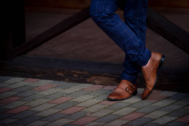 istock Low Section Of Businessman Wearing Shoes While Standing On Footpath 1059416544