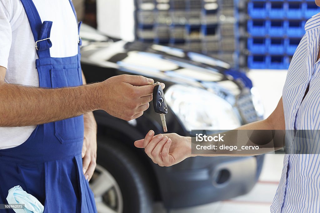 mechanic cropped view of mechanic giving car keys to female client Mechanic Stock Photo
