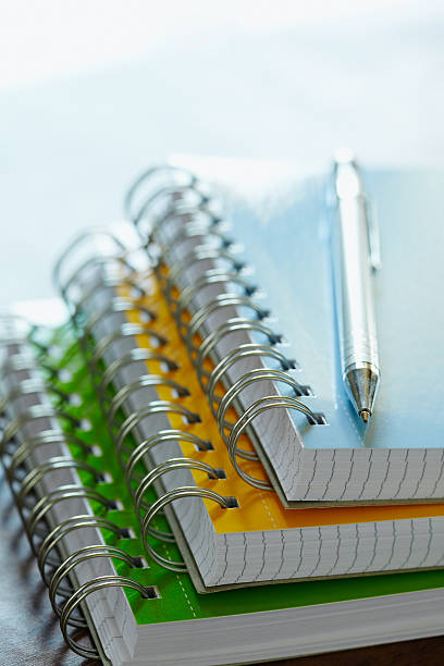 istock Metallic pen on a top of three colorful writing blocks 105942239