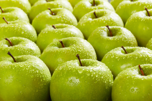large group of granny smith apples in a row. Selective focus